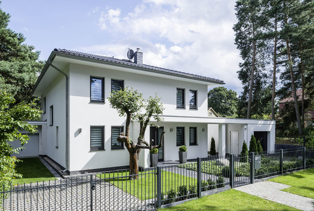 Dieses moderne Einfamilienhaus überzeugt durch seine Geradlinigkeit und Großzügigkeit. Ein überdachter Laubengang verbindet den Hauseingang mit der Garage.